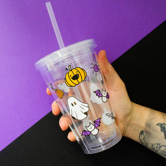 Halloween-themed reusable tumbler with straw, featuring fun designs of pumpkins, ghosts, and spiders, perfect for seasonal drinks